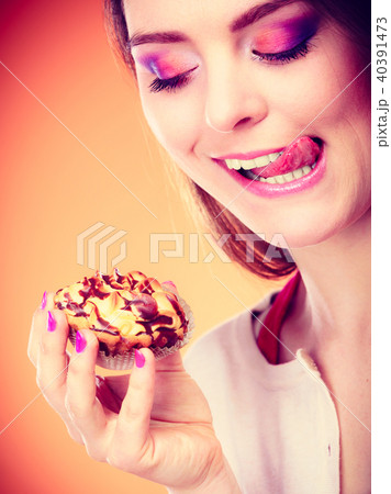 woman holds cake in hand licking lips woman holds cake in hand licking lips 40391473