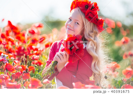 Cute happy blonde child girl is wearing wreath from red flowers in poppy field Cute happy blonde child girl is wearing wreath from red flowers in poppy field 40391675