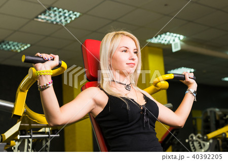 sport, fitness, lifestyle and people concept - Beautiful woman flexing muscles on gym machine 40392205