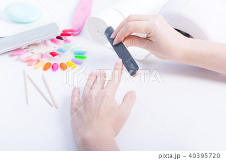 Woman doing manicure with black file on table 40395720
