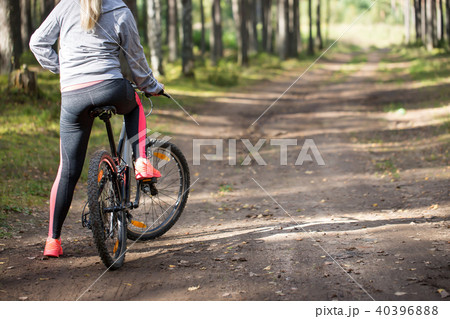 Woman riding a mountain bicycle along path Woman riding a mountain bicycle along path 40396888
