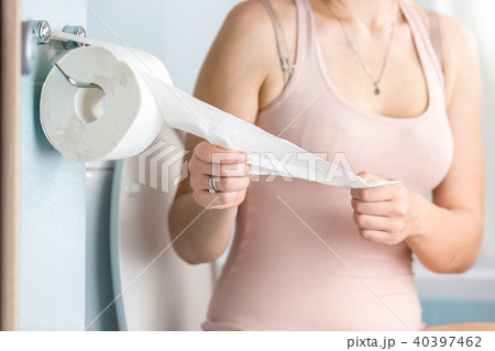 Closeup image of young woman tearing off toilet paper Closeup image of young woman tearing off toilet paper 40397462
