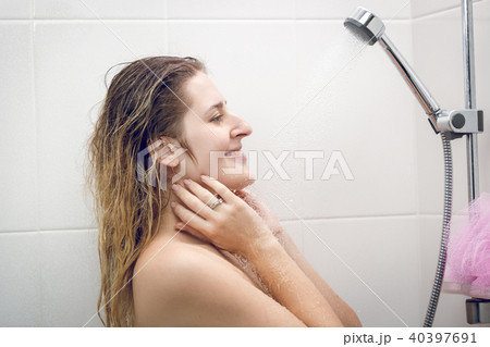 Toned closeup portrait of sexy young woman relaxing under shower 40397691