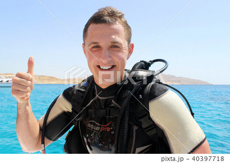 Happy Diver in a suit for diving shows trumb up 40397718