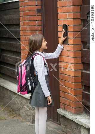 Cute teenage girl ringing in house doorbell after going to school 40398199