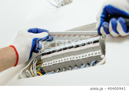 Electrician installing an electrical fuse box . Electrician installing an electrical fuse box . 40400941