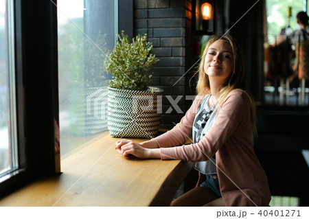 Young woman sitting near window at cafe and dreaming. Young woman sitting near window at cafe and dreaming. 40401271