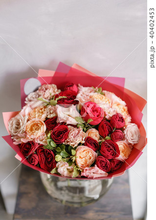 Bright red bouquet of beautiful flowers on wooden table. Floristry concept. Spring colors. the work Bright red bouquet of beautiful flowers on wooden table. Floristry concept. Spring colors. the work 40402453