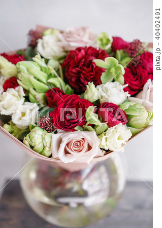 Bright red and white bouquet of beautiful flowers on wooden table. Floristry concept. Spring colors 40402491