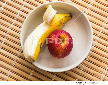 White bowl containing banana and apple. 40405992