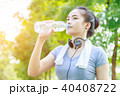 Young woman drinking water after running  40408722