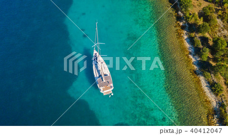 Aerial view of sailing boat anchoring next to reef Aerial view of sailing boat anchoring next to reef 40412047