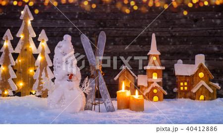 Christmas background with illuminated wooden village and snowman Christmas background with illuminated wooden village and snowman 40412886