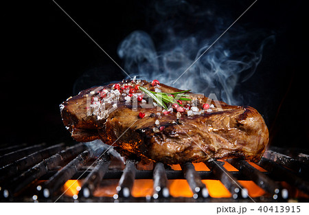 Beef steak on the grill grate, flames on background 40413915