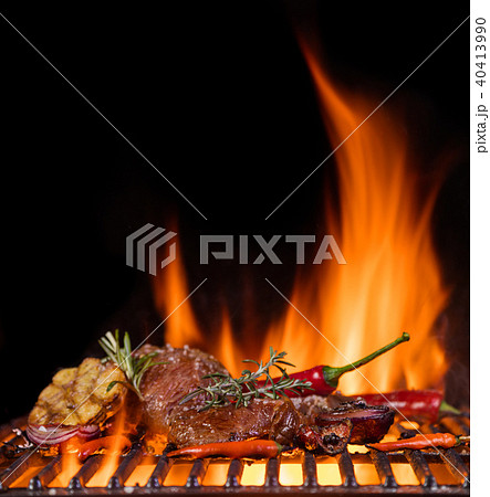 Beef steaks on the grill grate, flames on background 40413990