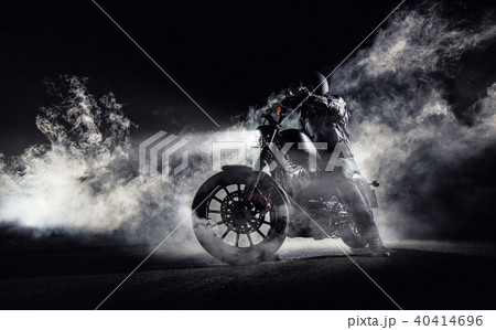 High power motorcycle chopper with man rider at night High power motorcycle chopper with man rider at night 40414696
