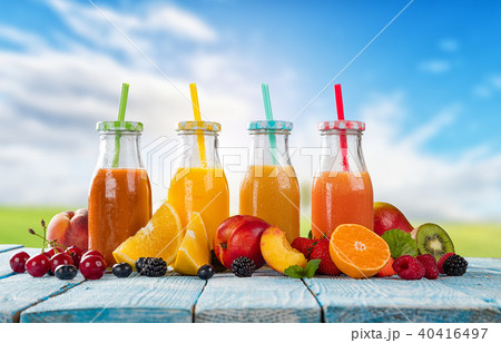 Fresh juice with fruit mix on wooden table - Stock Photo [40416497