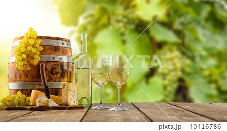 White wine served on wooden planks, vineyard on background 40416786