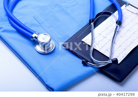 Medical stethoscope lying on patient medical history list, RX prescription and blue doctor uniform 40417299