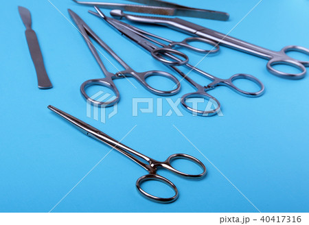 surgical instruments and tools including scalpels, forceps and tweezers arranged on a table for a 40417316