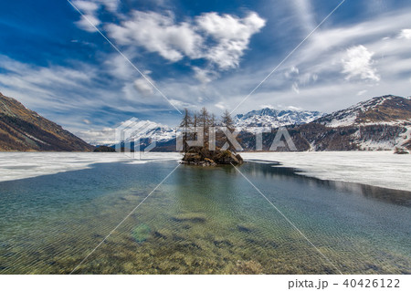 Thaw in Lake of the Swiss Alps. Small islet 40426122