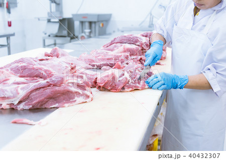 butcher cutting the fresh meat in ham factory butcher cutting the fresh meat in ham factory 40432307