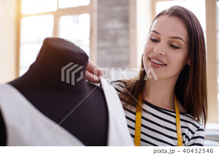 Positive female dressmaker fitting dress 40432546