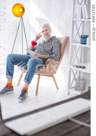 Charming elderly man posing while watching video on tablet 40432583