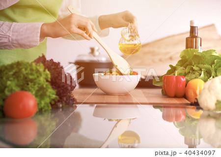 Close Up of human hands cooking vegetable salad in kitchen on the glass table with reflection 40434097