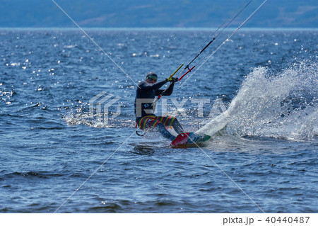 Male kiteboarder rides on a board on a large river Male kiteboarder rides on a board on a large river 40440487