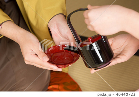 お屠蘇を盃に注ぐ 40440723