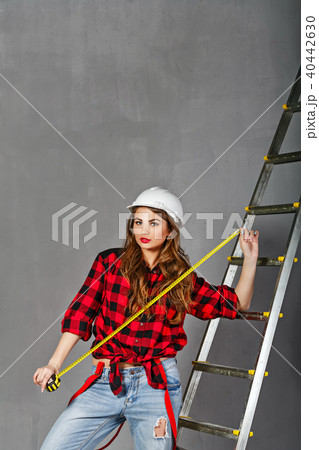 Woman builder holds tape measure Woman builder holds tape measure 40442630