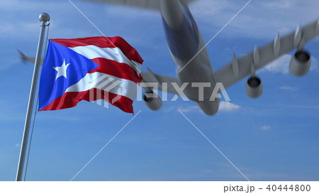 Commercial airplane flying above waving flag of Puerto Rico. 3D rendering 40444800