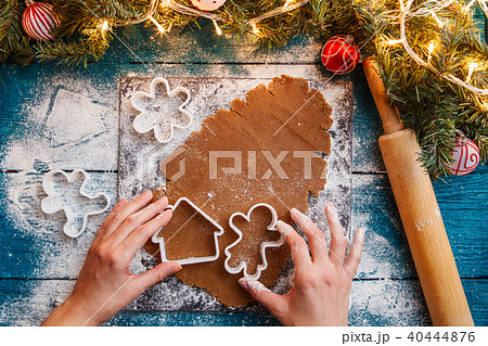 Picture of human hands, rolling pin, dough, spruce branches, garlands, biscuit molds Picture of human hands, rolling pin, dough, spruce branches, garlands, biscuit molds 40444876