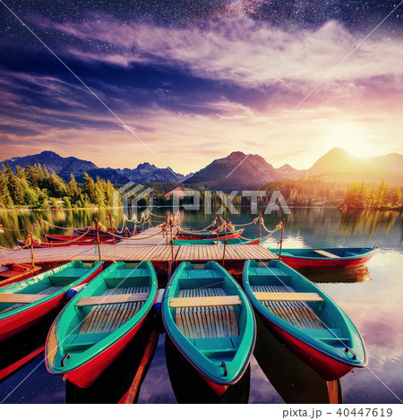 Boat on the dock surrounded mountains, starry sky . Fantastic Sh 40447619