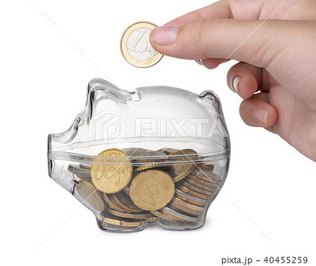Close up of hand putting coin into piggy bank Close up of hand putting coin into piggy bank 40455259
