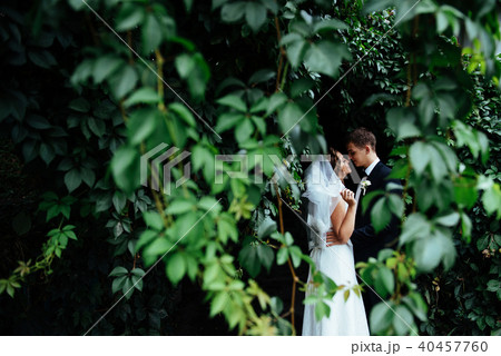 beautiful young wedding couple kissing , blonde bride with flowe 40457760