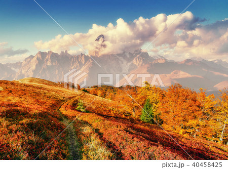 Autumn road in the mountains. Fantastic cumulus clouds, dramatic Autumn road in the mountains. Fantastic cumulus clouds, dramatic 40458425