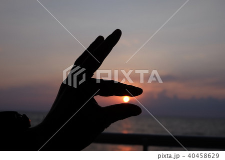 夕日を掴むの写真素材