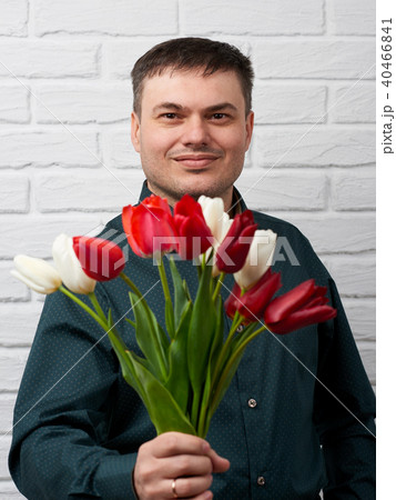 man with flowers on white brick wall background 40466841