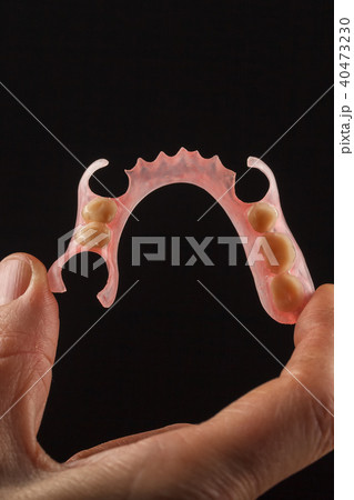 Dental prosthesis in the hand of the dentist. 40473230