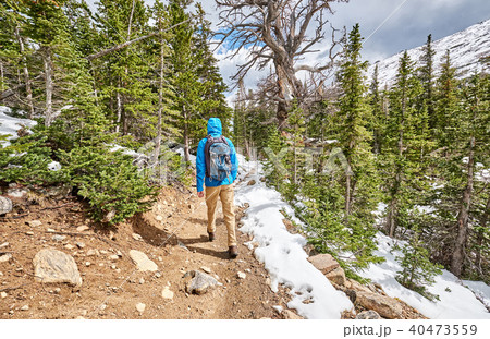 Tourist with backpack hiking on snowy trail Tourist with backpack hiking on snowy trail 40473559