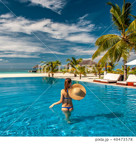 Woman with hat at beach pool in Maldives Woman with hat at beach pool in Maldives 40473578