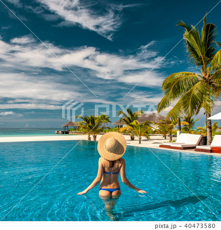 Woman with hat at beach pool in Maldives 40473580