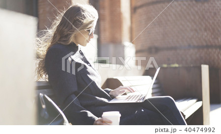 Serious girl in glasses, coffee, notebook, bench 40474992