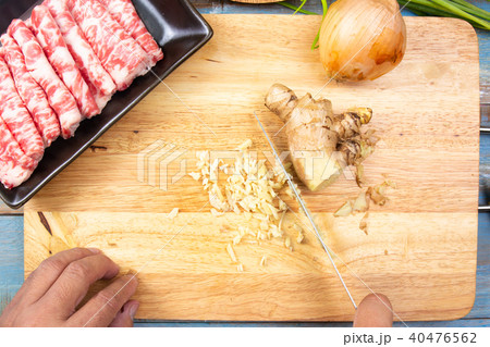 Chef slicing ginger before cooking 40476562