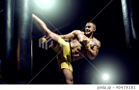 Thai boxer punch kick by punching bag Thai boxer punch kick by punching bag 40479181