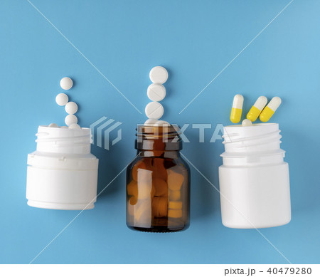 Various pills bottles and white round pills 40479280