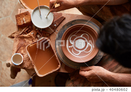 Scary face alike handmade potter mug on a wooden shelf, close-up, shellow depth of field. 40480602