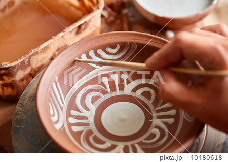 Scary face alike handmade potter mug on a wooden shelf, close-up, shellow depth of field. 40480618